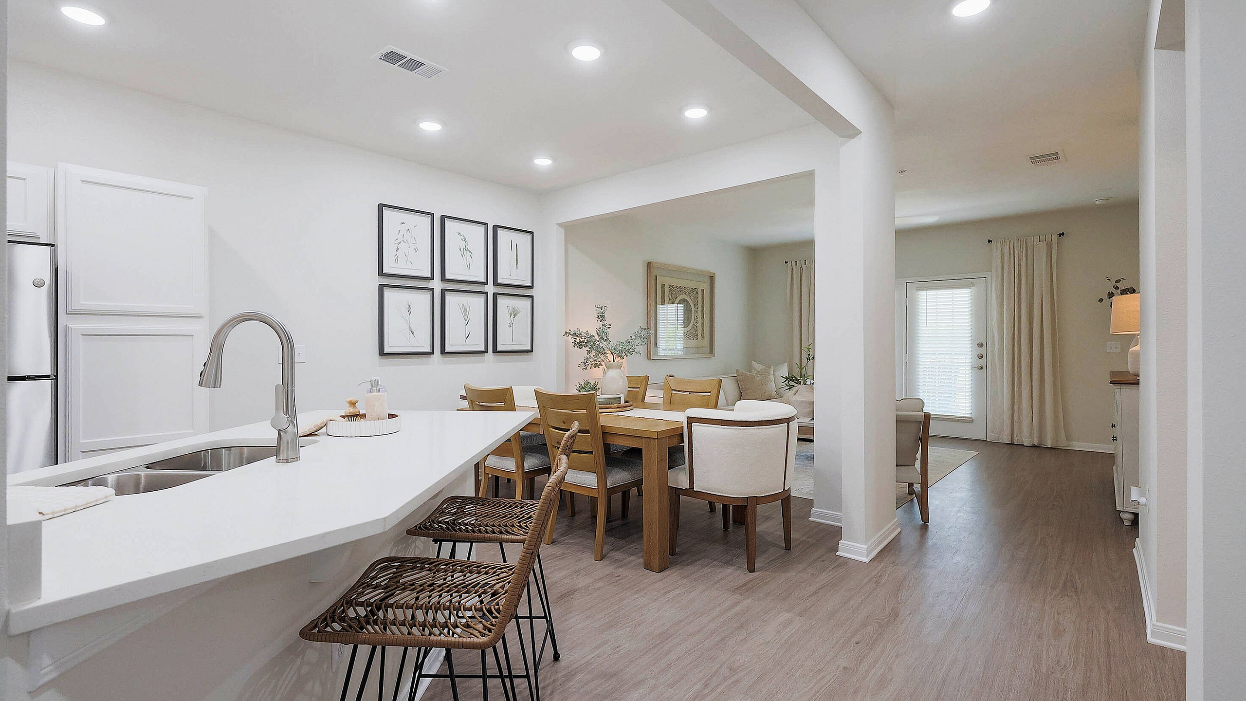 Elegant open-concept kitchen and dining area with modern finishes, featuring a sleek breakfast bar and cozy seating.