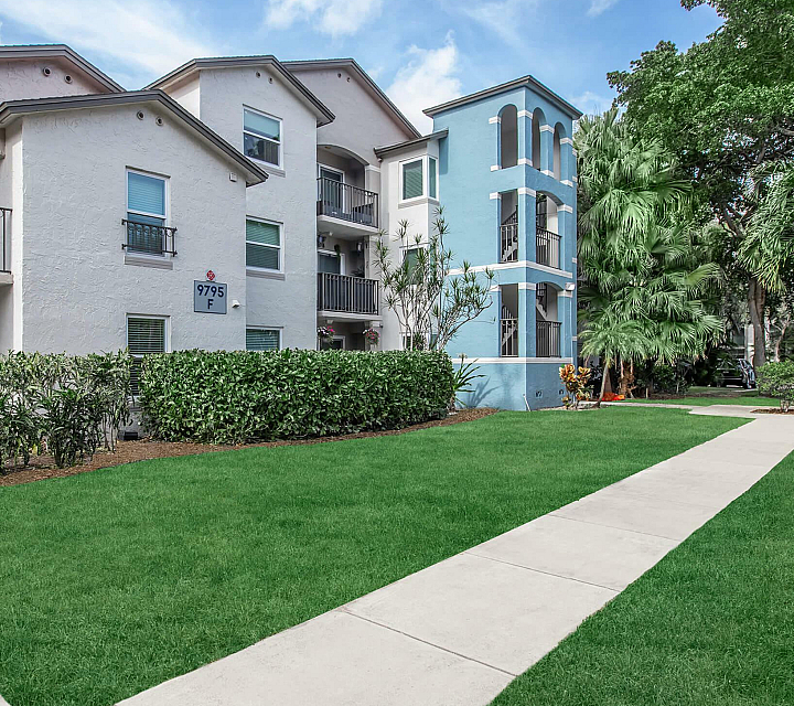 Latitude Pointe Apartments Building Exterior with Private Balconies and Lush Landscaping