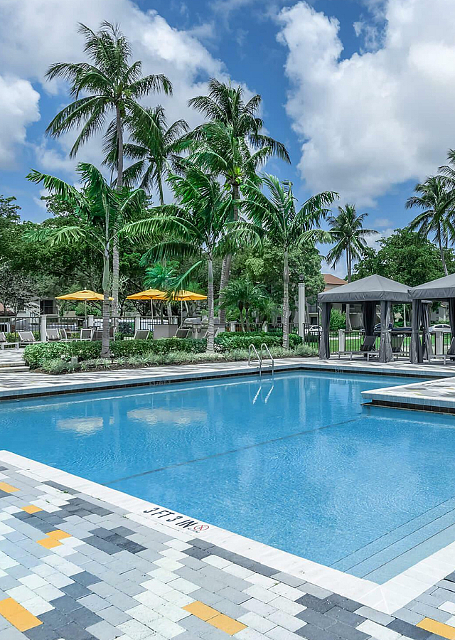 Latitude Pointe Swimming Pool with Cabanas, Lounge Chairs and Palm Trees