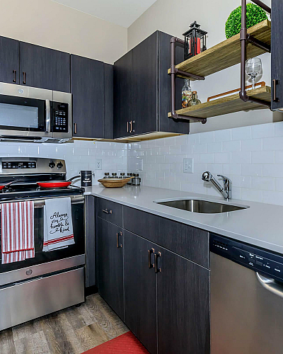 Park Sixty Four Apartments Modern Kitchen with Dark Cabinetry, White Countertops, Stainless Appliances and Custom Shelving