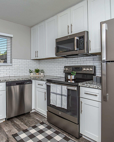 Southwood Townhomes Renovated Kitchen with White Cabinetry and Tile Backsplash and Stainless Steel Appliances