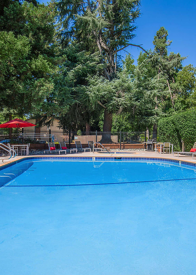 Southwood Townhomes Swimming Pool with Red Umbrellas and Loungers