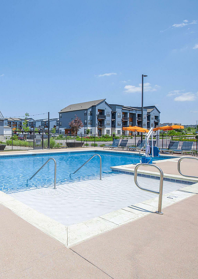 The Depot Zero Entry Pool with Chaise Loungers and Orange Umbrellas