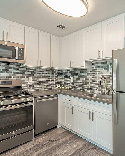 Enclave at Town Square Kitchen with White Shaker Cabinetry, Stainless Steel Appliances and Quartz Countertops