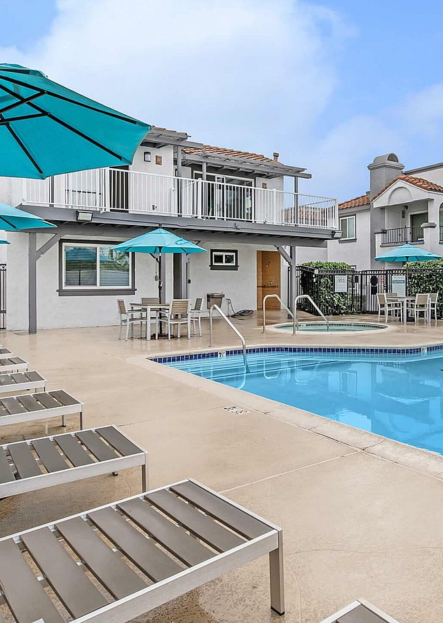 Enclave at Town Square Swimming Pool with Teal Umbrellas and Loungers