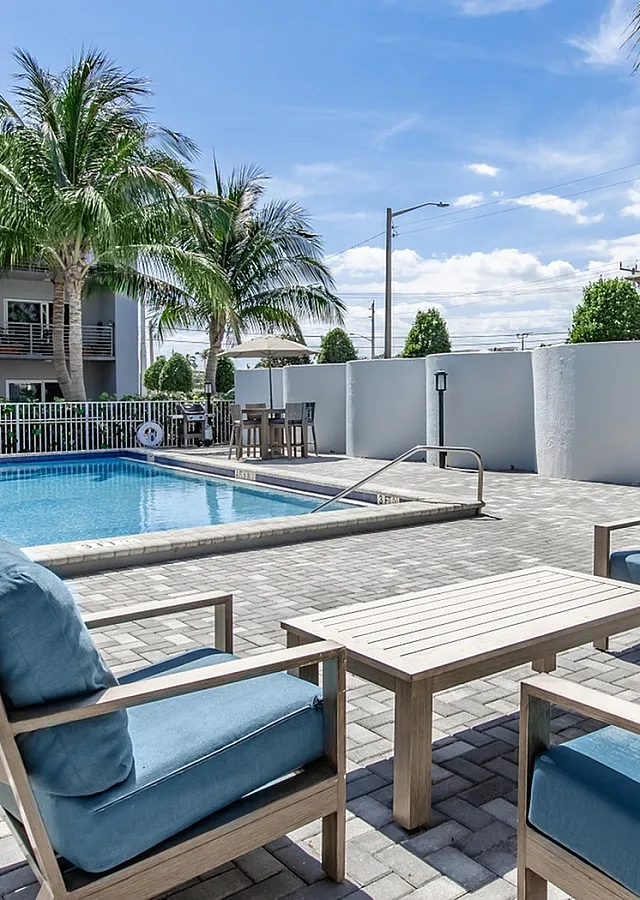 2500 Boca Swimming Pool with Comfortable Blue Cushioned Seating and Hightop Tables Surrounded by Palm Trees