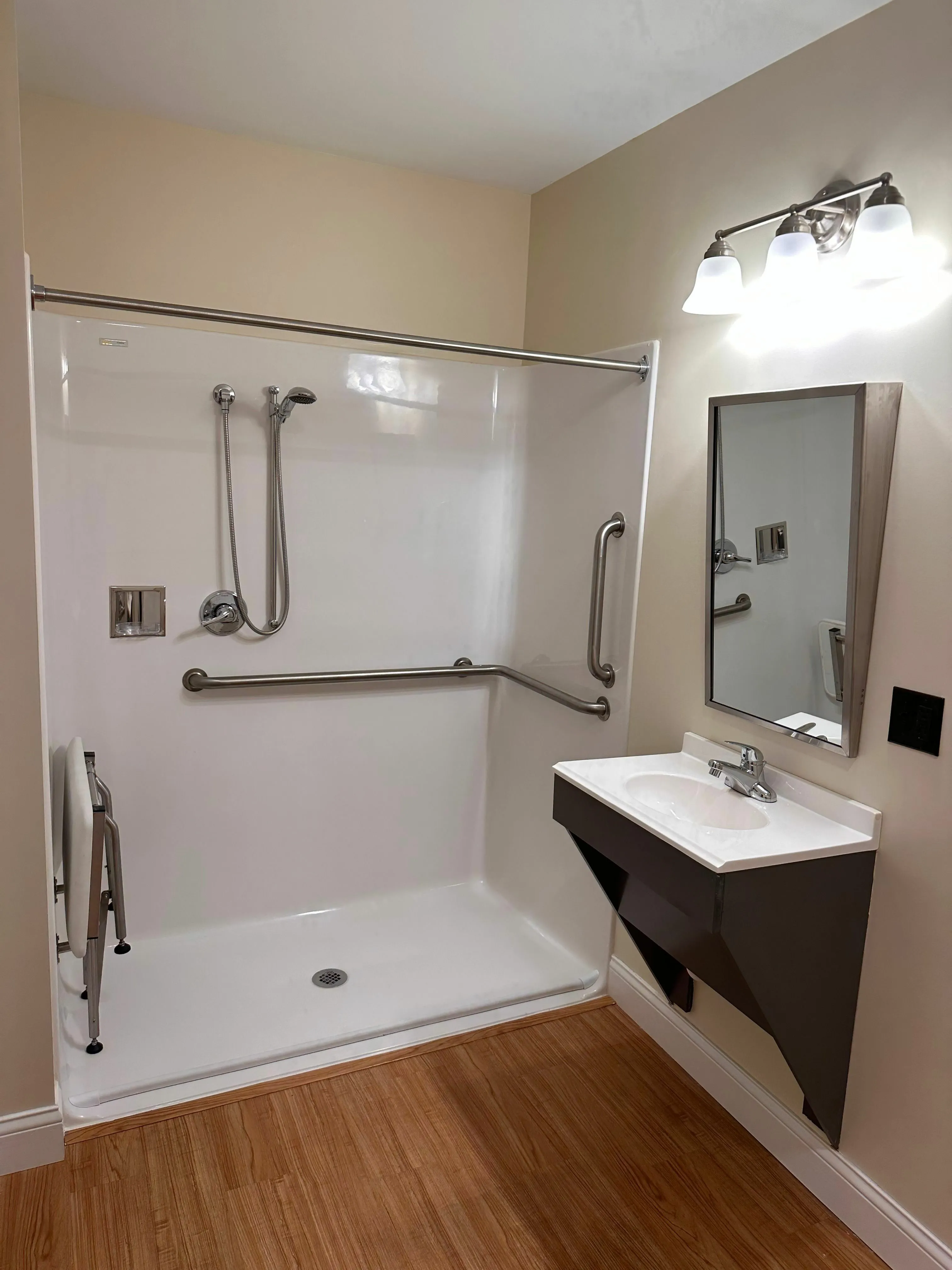Modern bathroom with accessible walk-in shower, sleek fixtures, and elegant lighting.