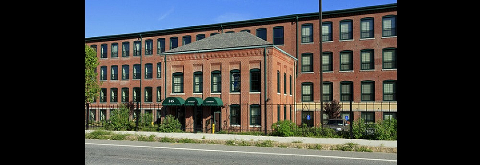 Charming brick apartment building with classic architecture and manicured greenery, ideal for modern urban living.