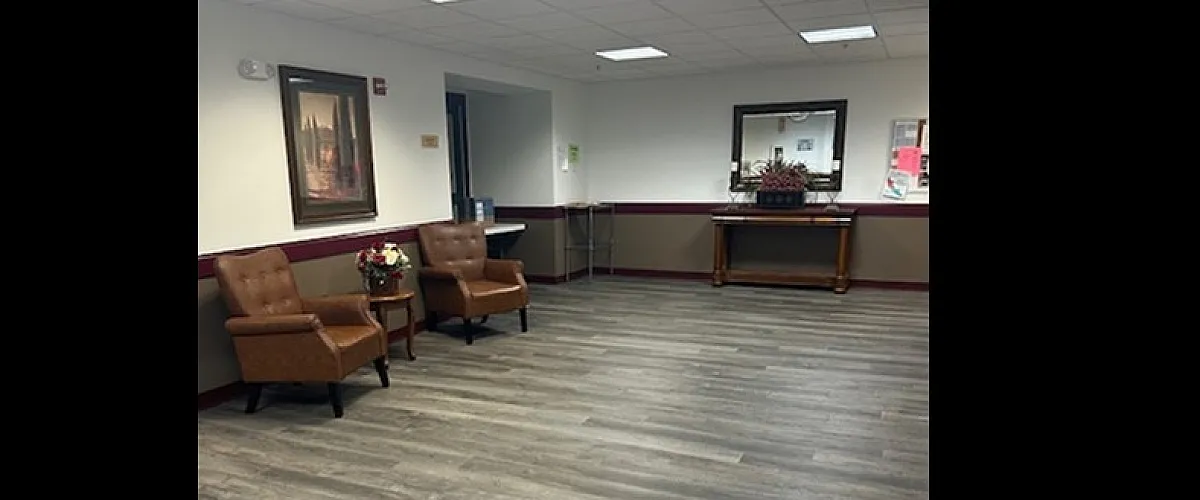 Inviting apartment lobby with elegant seating, modern wood flooring, and tasteful decor for a welcoming atmosphere.