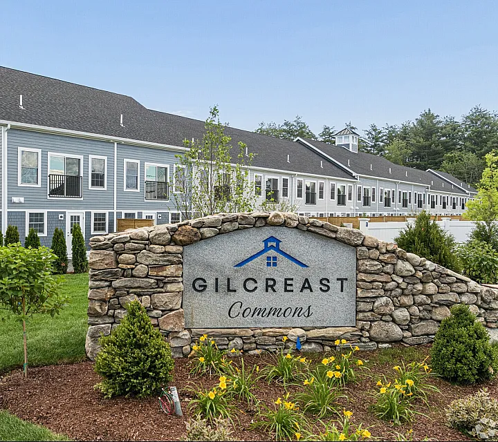 Charming residential community with modern gray townhouses and beautifully landscaped gardens at Gilcreast Commons.