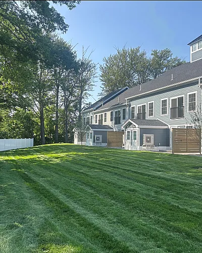 Charming apartment complex with beautifully manicured lawns, showcasing modern architecture and lush green surroundings.