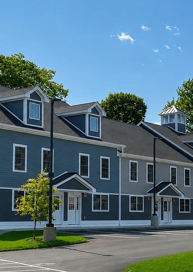 Charming blue multi-story townhouse with classic architecture, surrounded by lush greenery and bathed in sunlight.