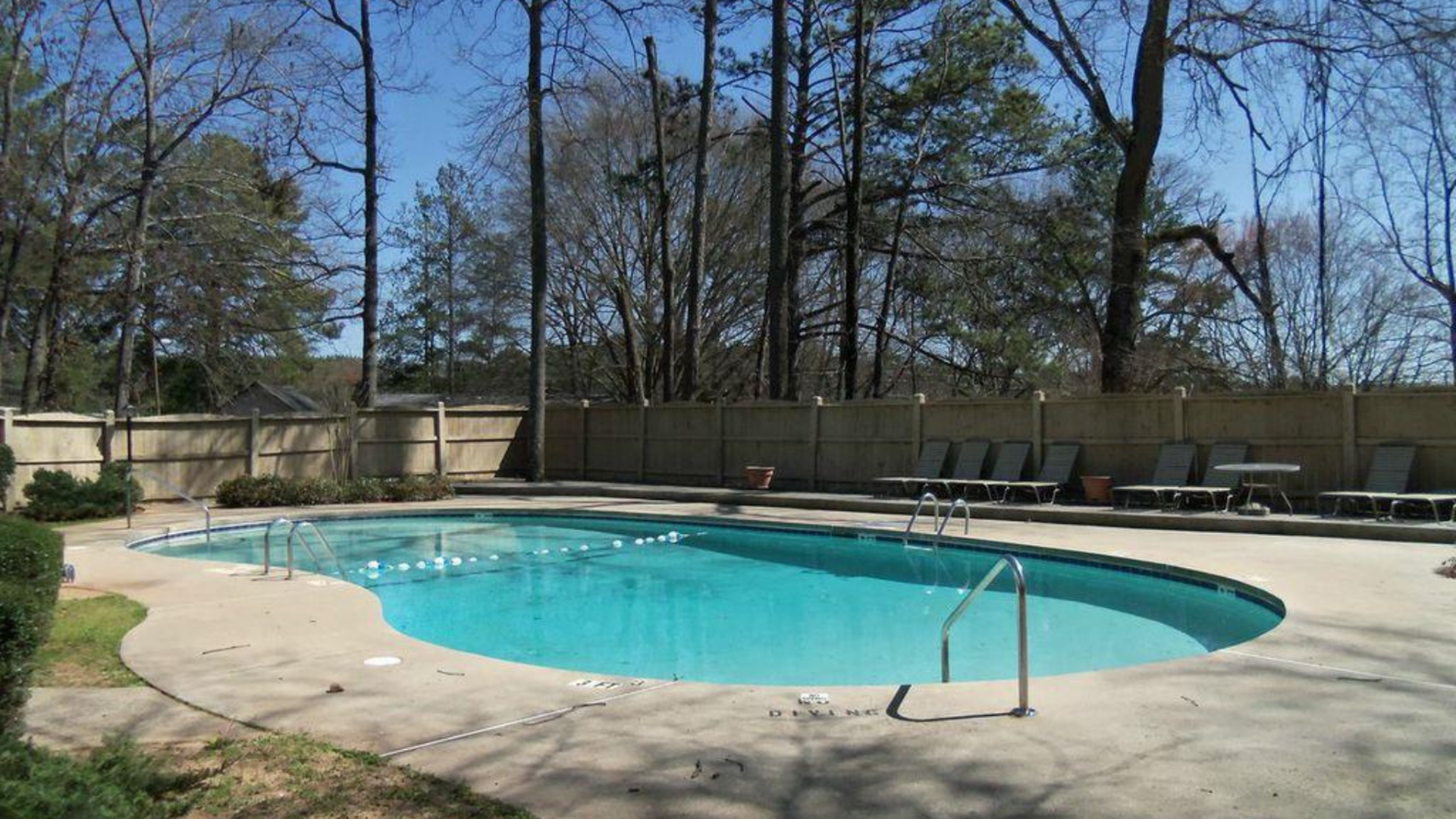 swimming pool with tanning chairs and privacy fence at reserve stockbridge
