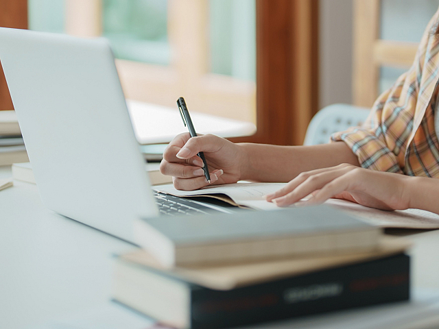 Inviting workspace with modern laptop, books, and a cozy atmosphere, perfect for productive studying.