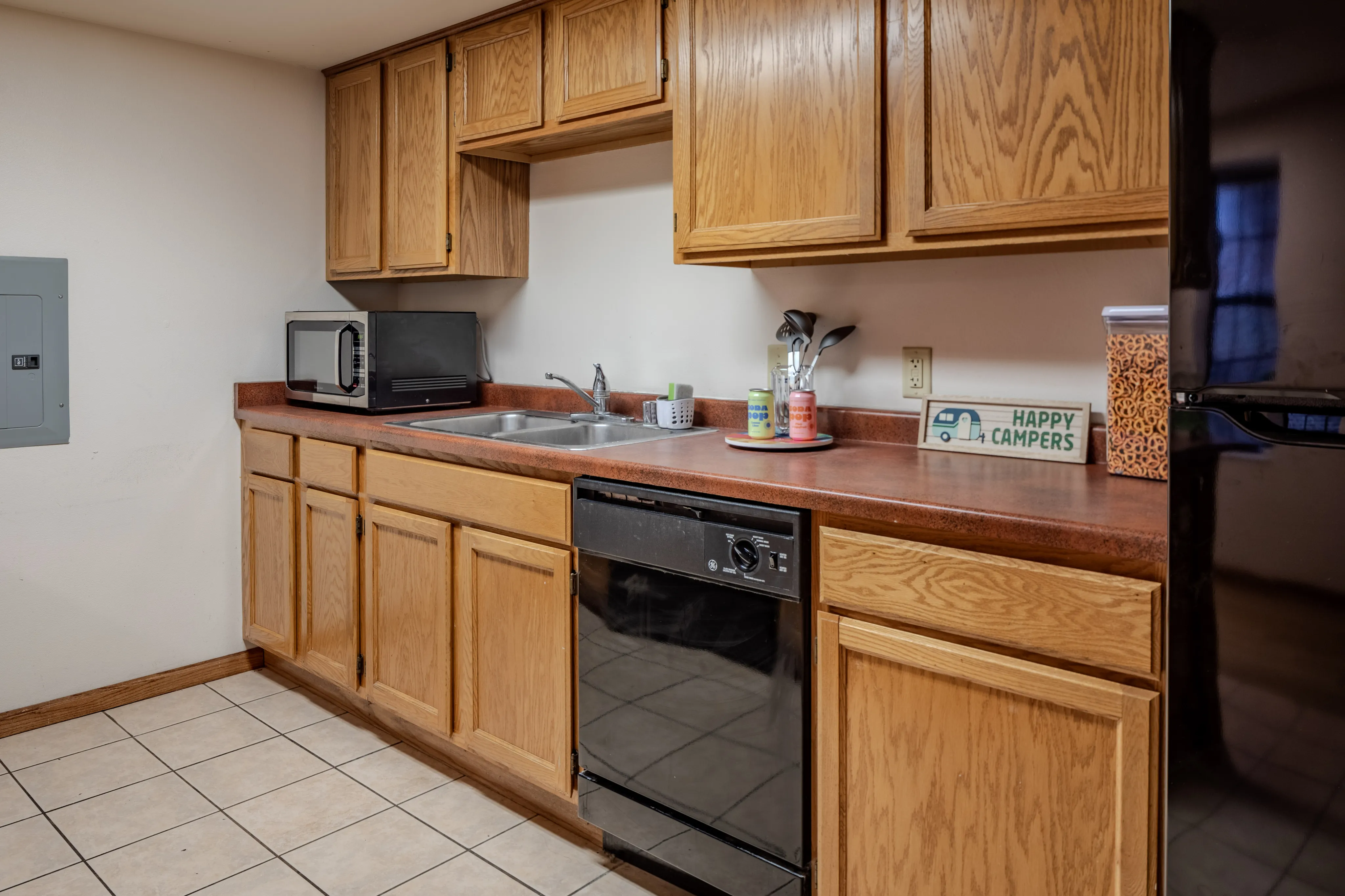 Inviting kitchen with wooden cabinets, modern appliances, and tile flooring.