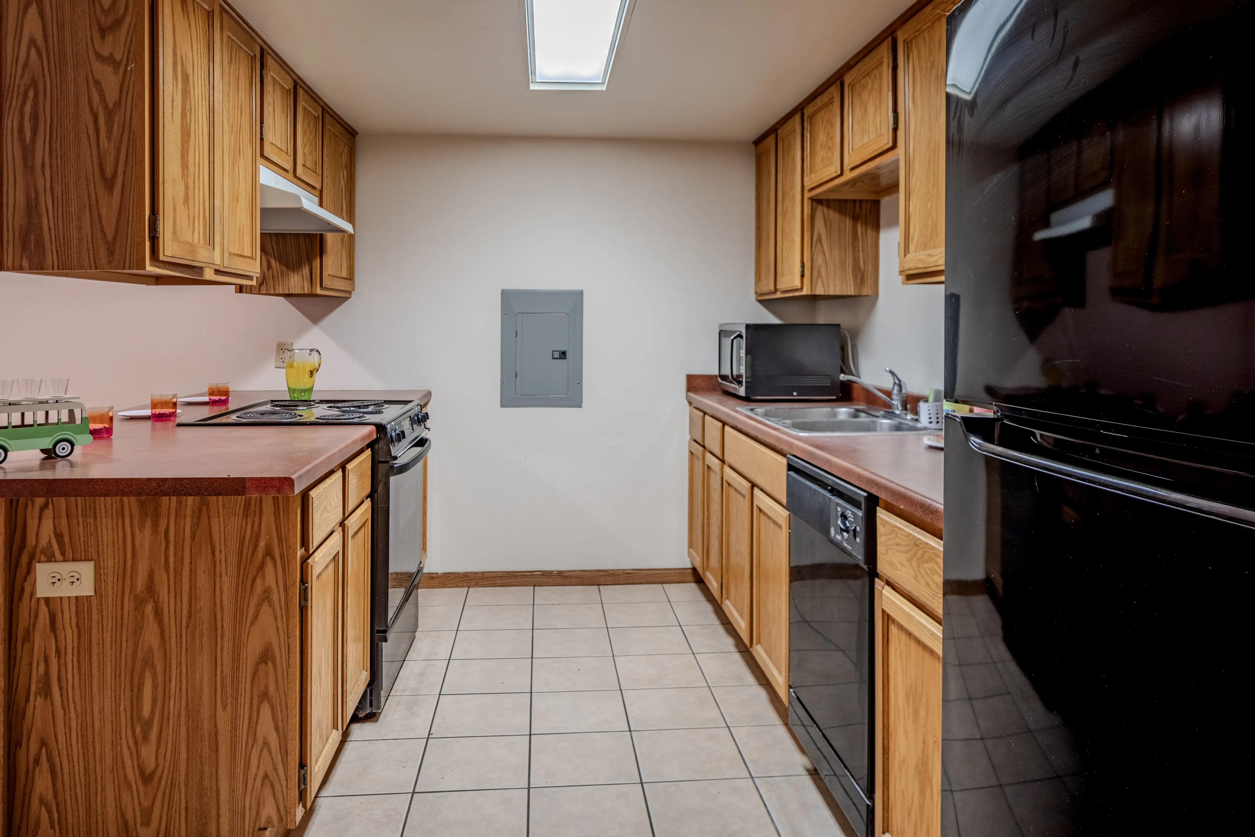 Inviting kitchen with wooden cabinetry, modern appliances, and tiled flooring.