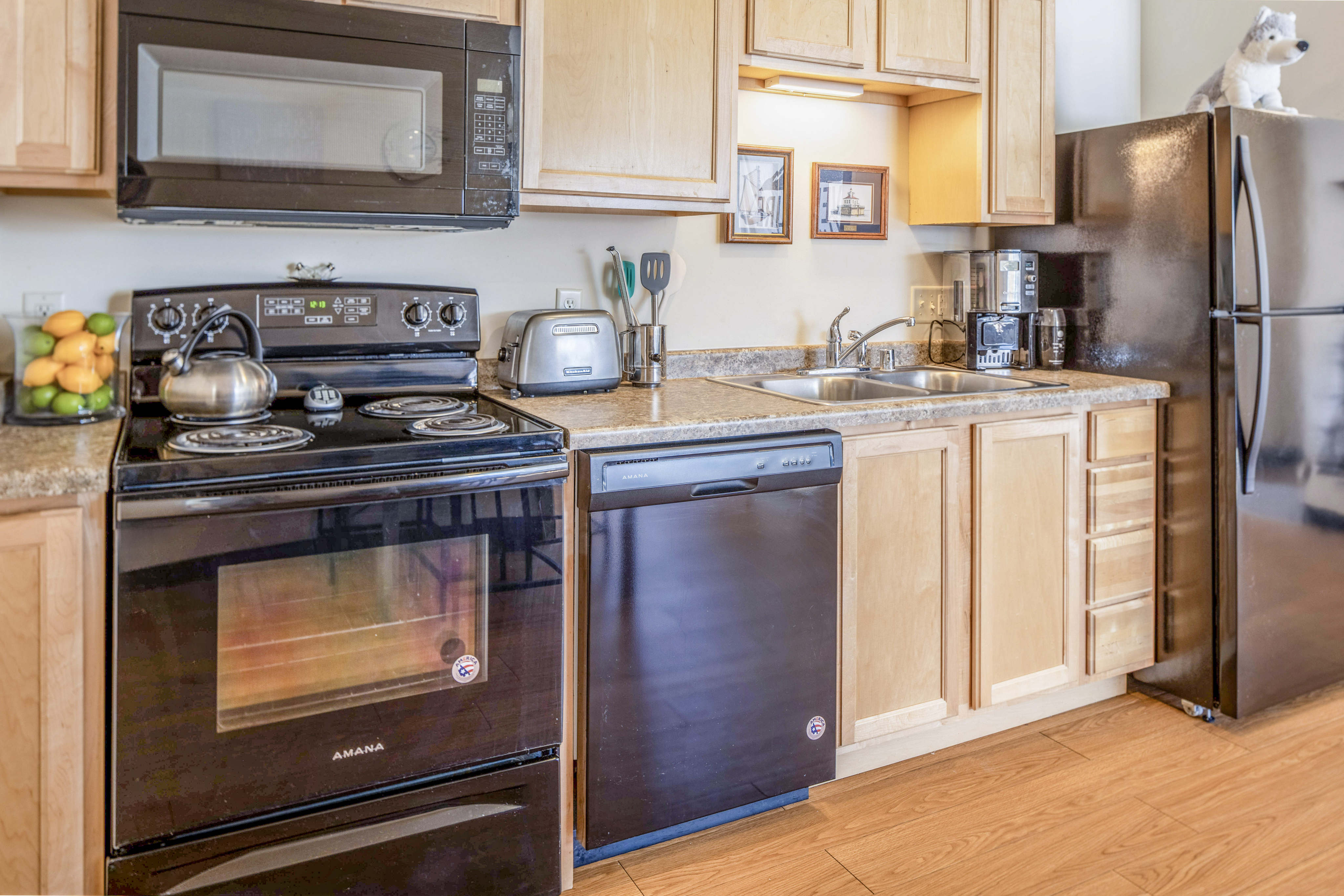 Modern kitchen with sleek black appliances, wooden cabinets, and stylish countertops.