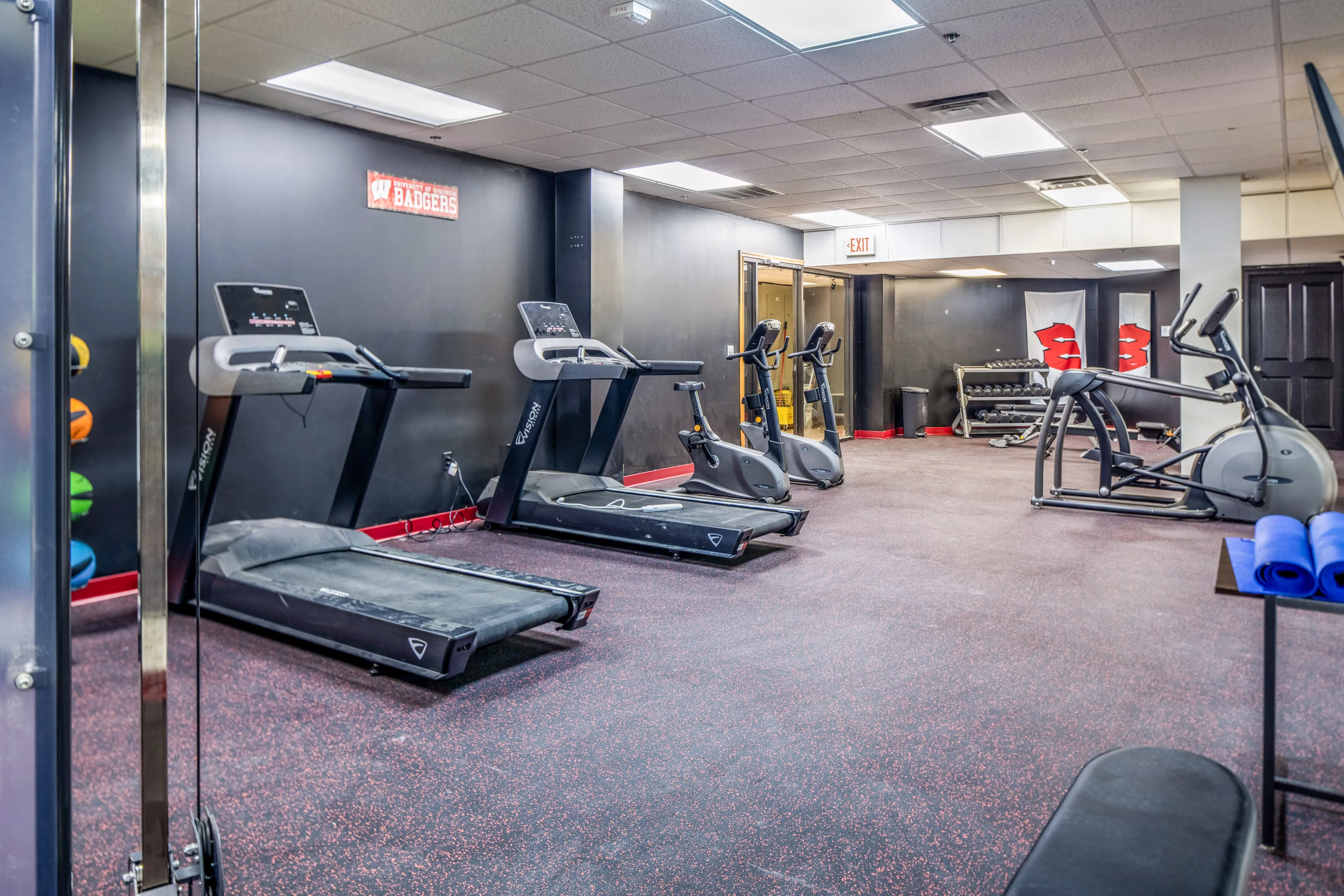 Modern gym with treadmills, exercise bikes, and strength training equipment.