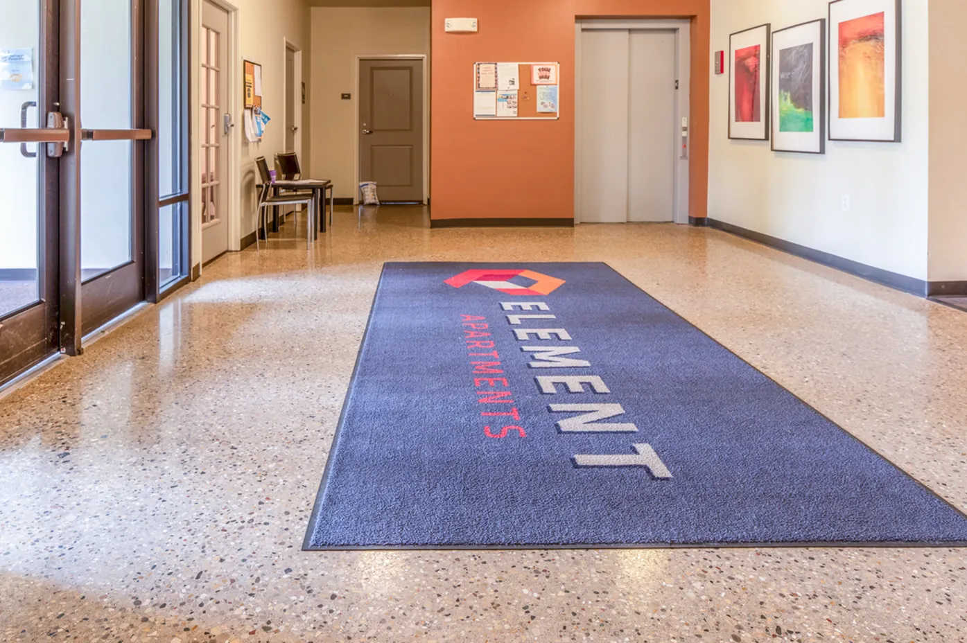 Inviting lobby of Element Apartments featuring elegant lighting, modern decor, and a welcoming floor mat.