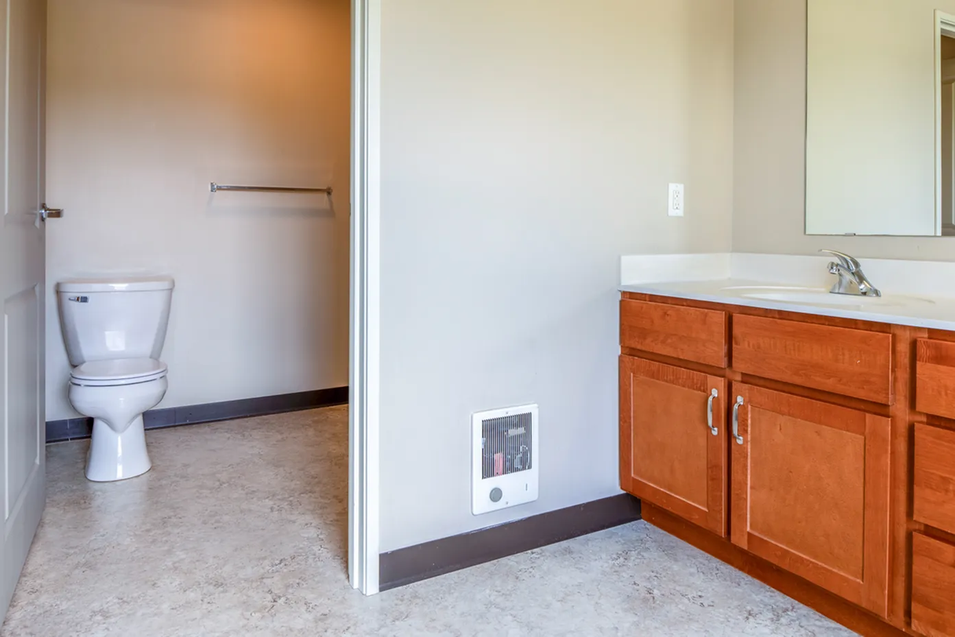 Modern bathroom with sleek sink area, wooden cabinets, and a clean, bright atmosphere.