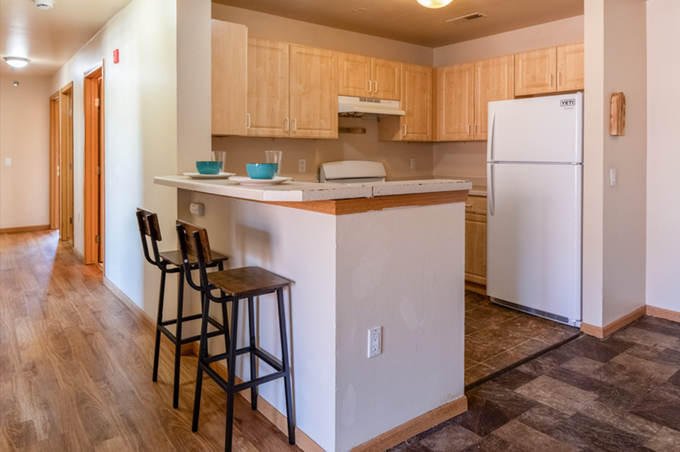 Inviting kitchen with warm wooden cabinetry and stylish bar seating, perfect for cozy dining moments.