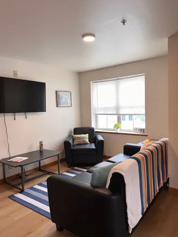 Model Unit-2 Bedroom including 3 seat couch, lounge chair, coffee table, side table and flat screen tv. Also featuring an in-unit washer and dryer included in every unit