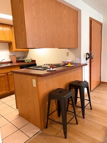 Kitchen-2 Bedroom Model Unit kitchen with all appliances included; stove, refrigerator, microwave, and dishwasher. Also included is breakfast bar and stools