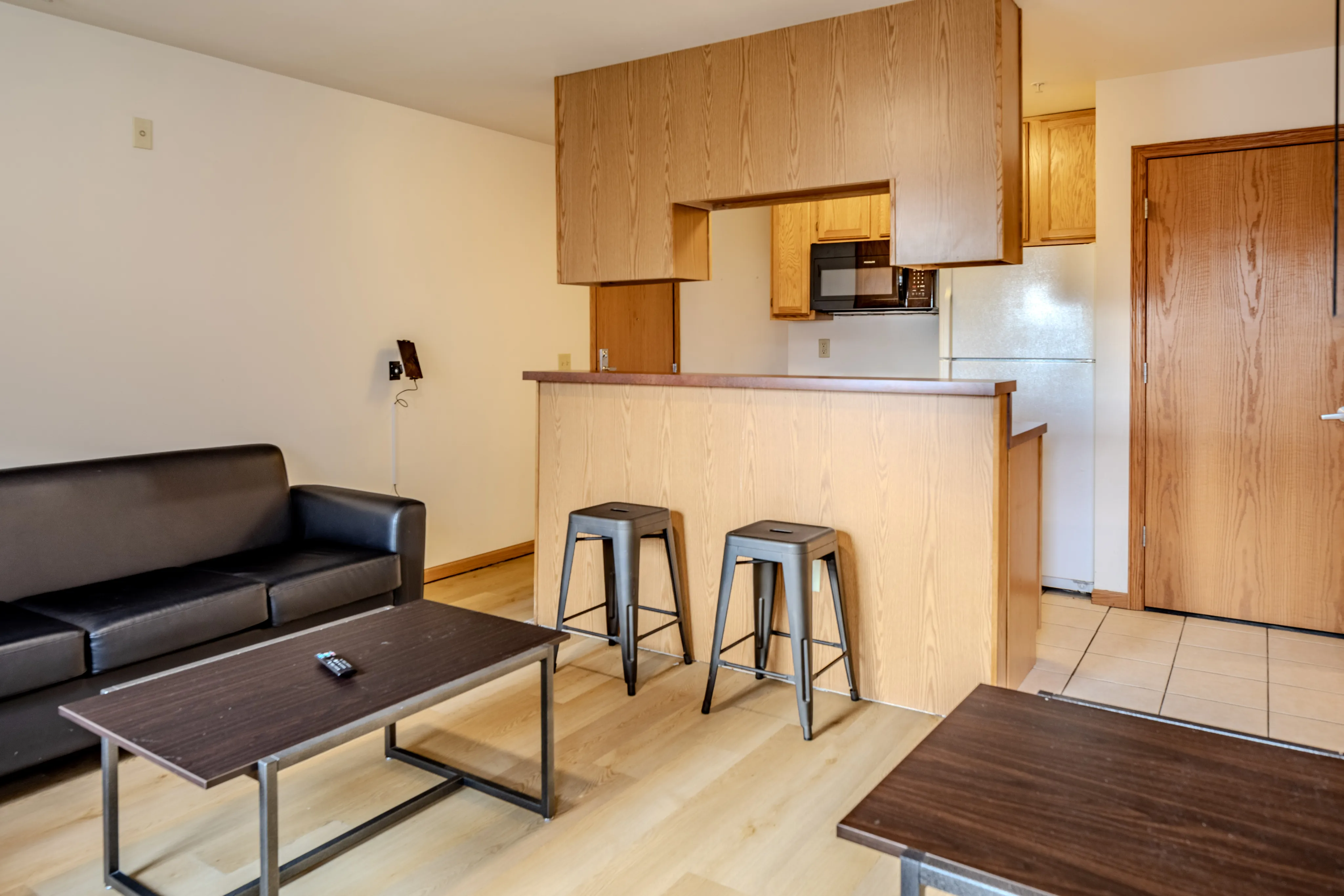 Cozy living area with modern kitchen and seating in an open-plan apartment.