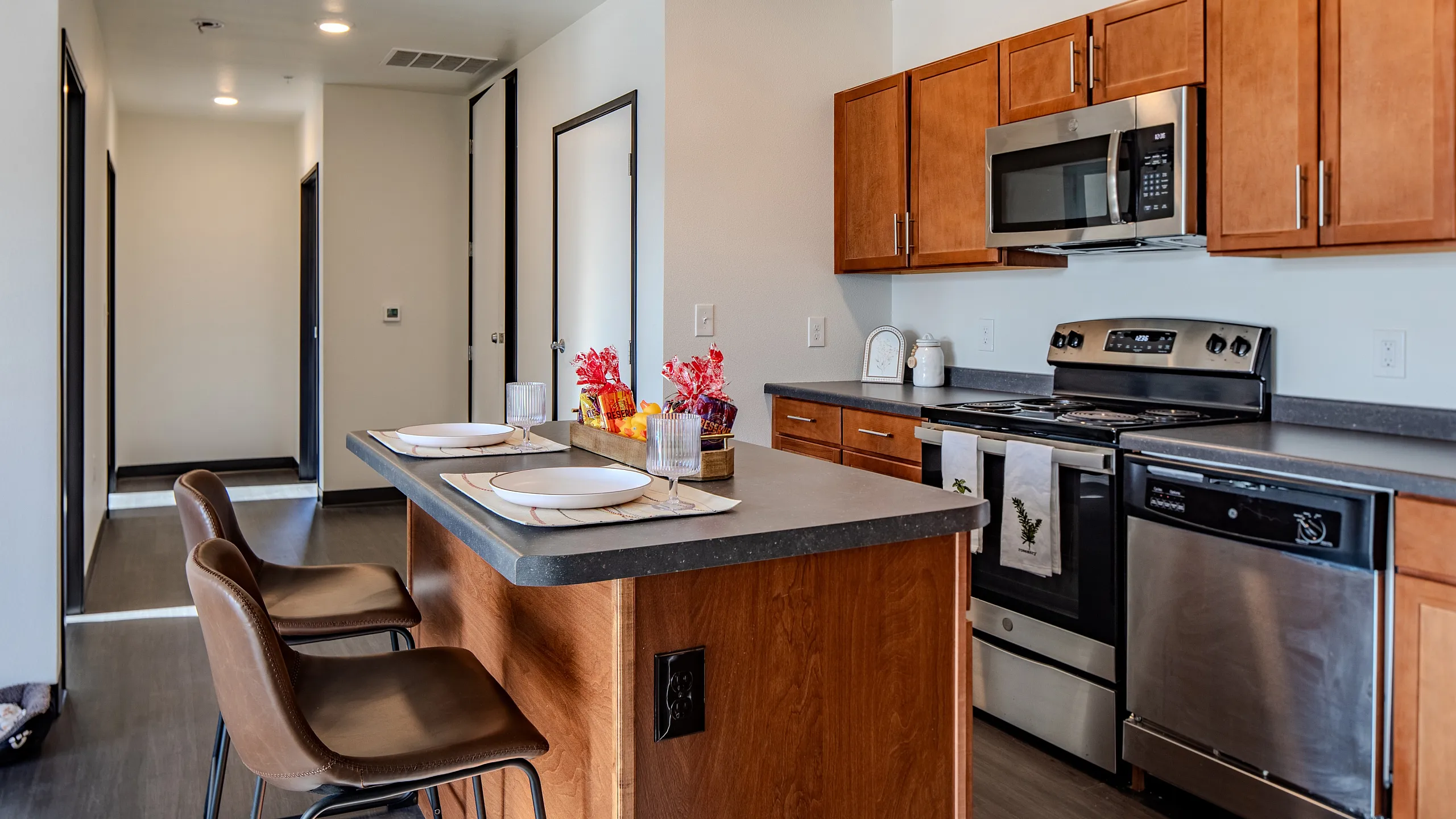 Contemporary kitchen with wooden cabinetry, stainless steel appliances, and a central island.