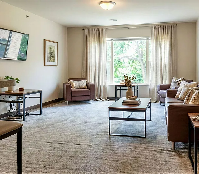 Inviting living room with chic decor, featuring a sleek sofa set, modern coffee table, and large window allowing ample natural light.
