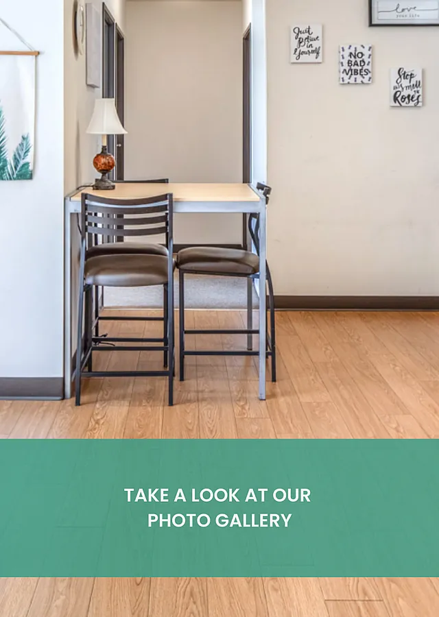 Inviting apartment corner with modern bar stools, sleek wooden flooring, and motivational wall art.