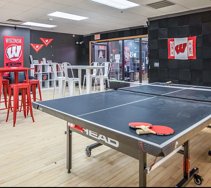 Vibrant recreational space with a sleek ping pong table and bold red seating, ideal for entertainment and relaxation.