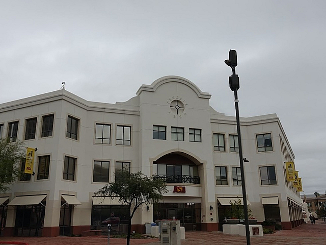 Elegant three-story building with classic architectural details, featuring large windows and a welcoming entrance, situated on a charming red brick pathway.