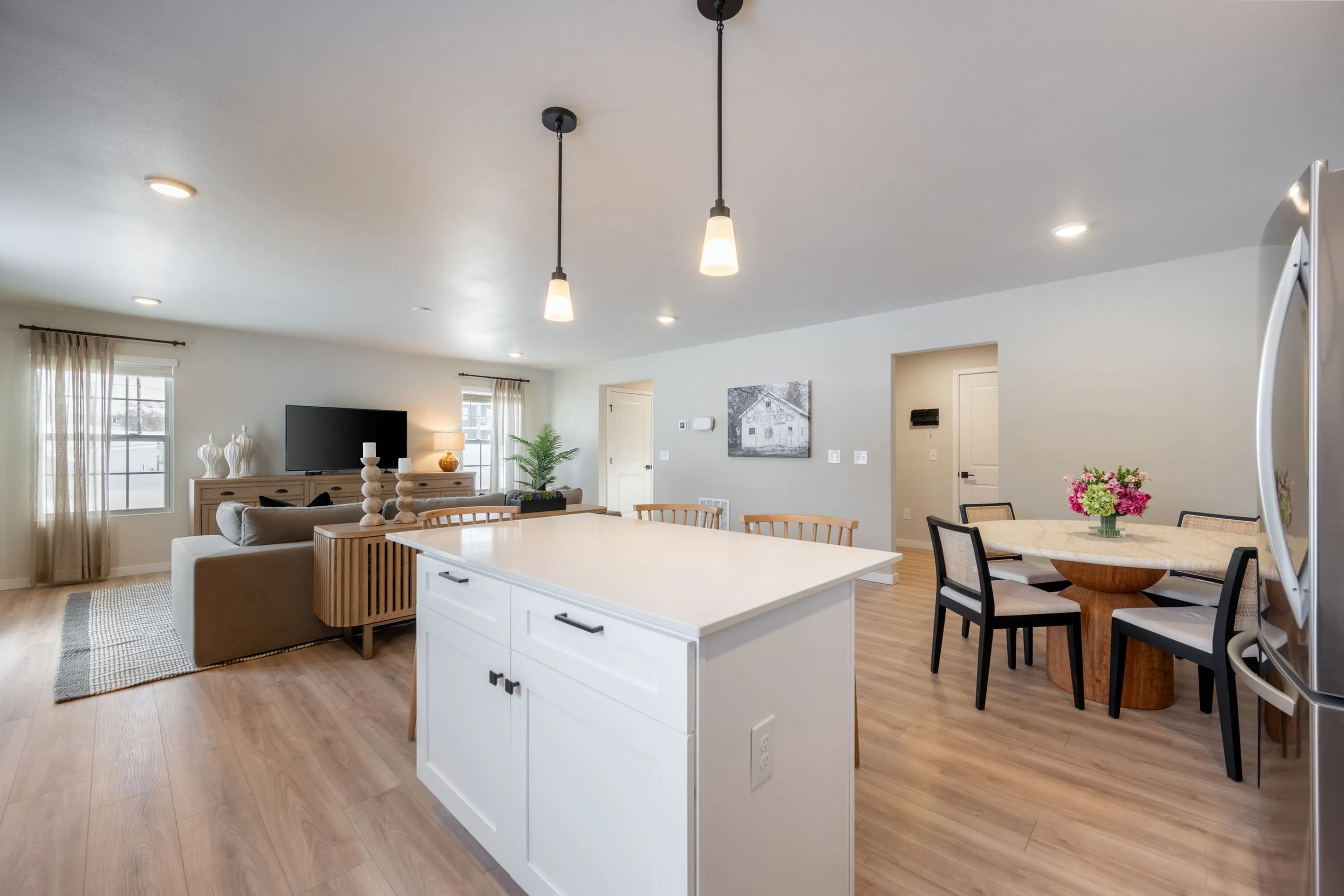 Bright and spacious open-concept living area featuring modern kitchen island, elegant dining space, and cozy lounge with stylish decor.