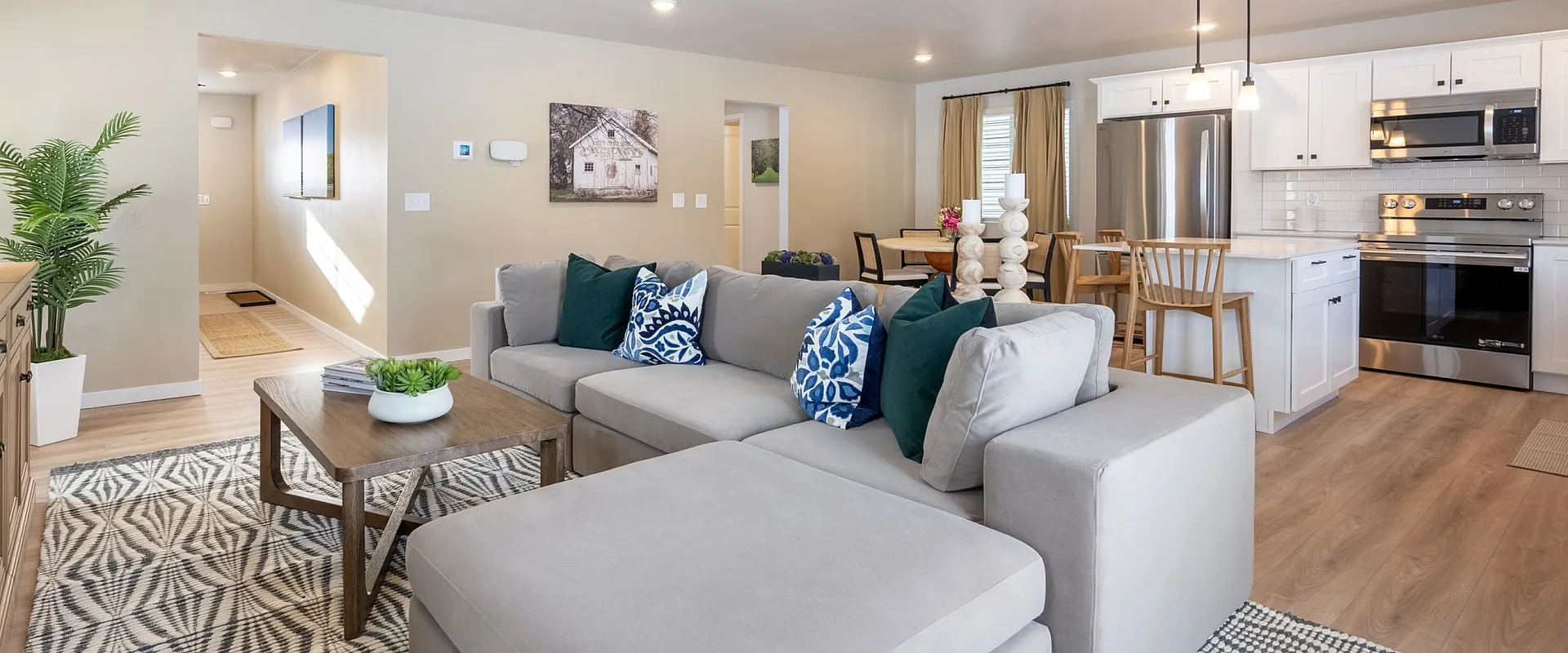 Modern open-concept living space with cozy sectional, elegant kitchen, and stylish dining area.