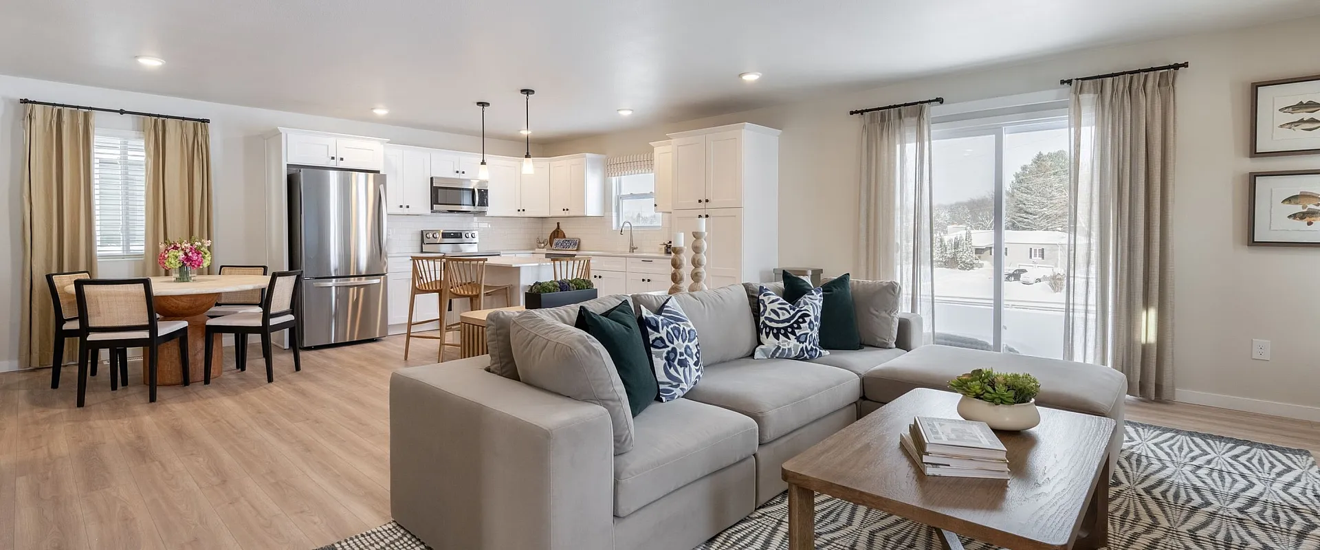Bright and modern living area with open-concept kitchen and dining space, featuring sleek stainless steel appliances, elegant decor, and abundant natural light.