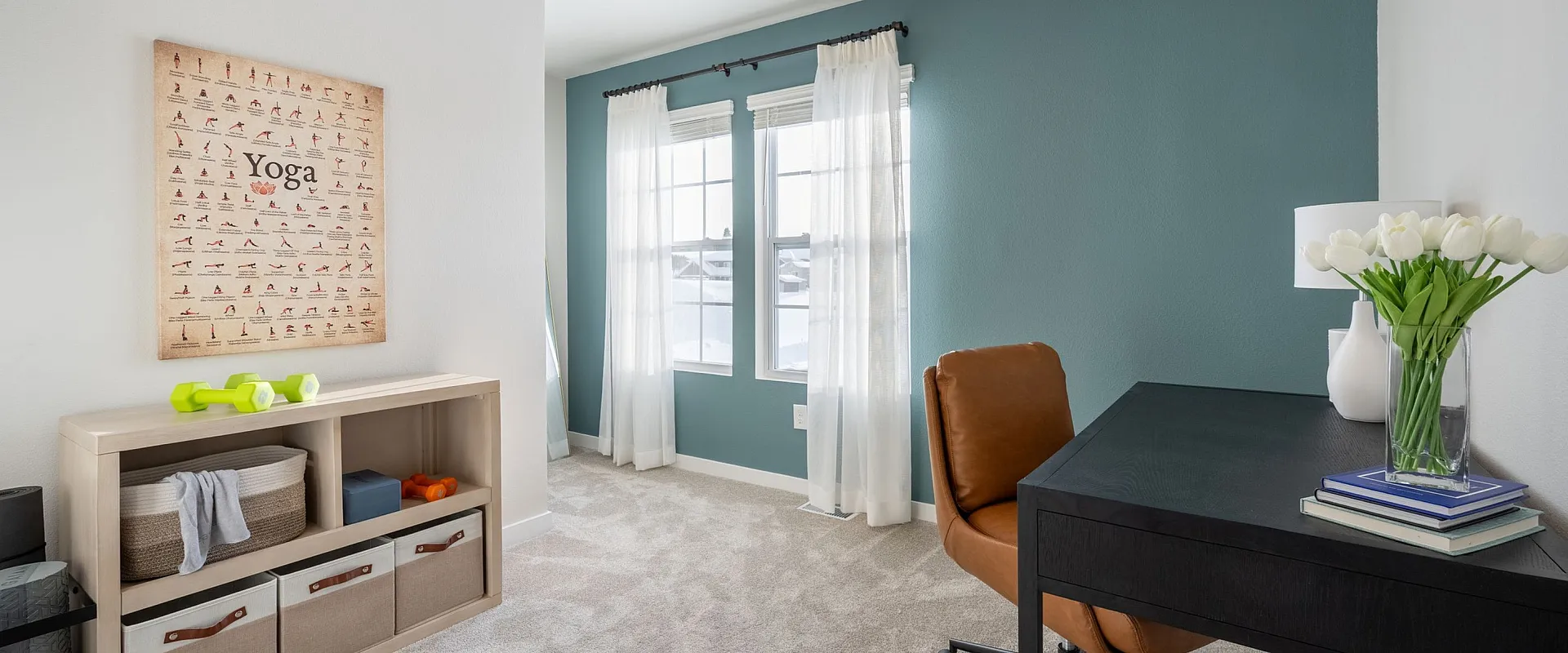 Bright home office featuring a stylish leather chair, elegant black desk, and yoga-themed decor. Spacious and filled with natural light.