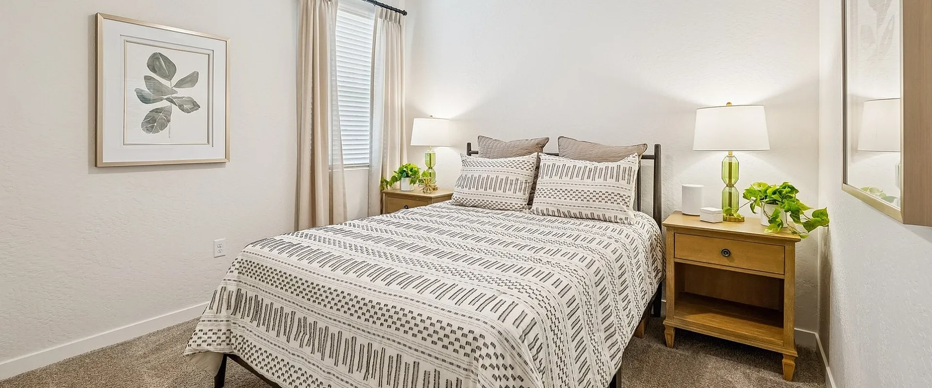 Elegant bedroom with cozy patterned bedding, natural wood nightstands, and modern lighting, exuding warmth and comfort.