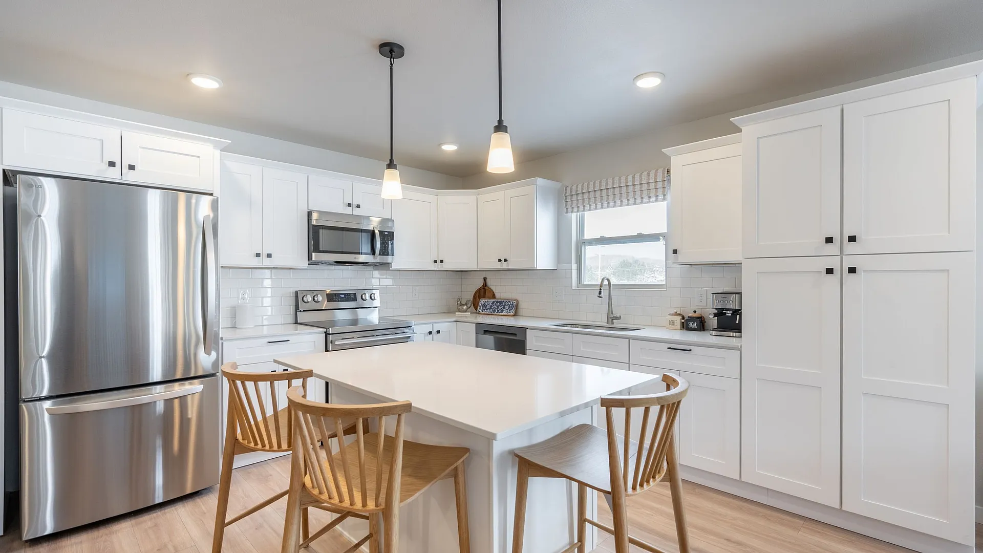 Modern kitchen with sleek stainless steel appliances, elegant white cabinetry, and a spacious island with stylish seating.