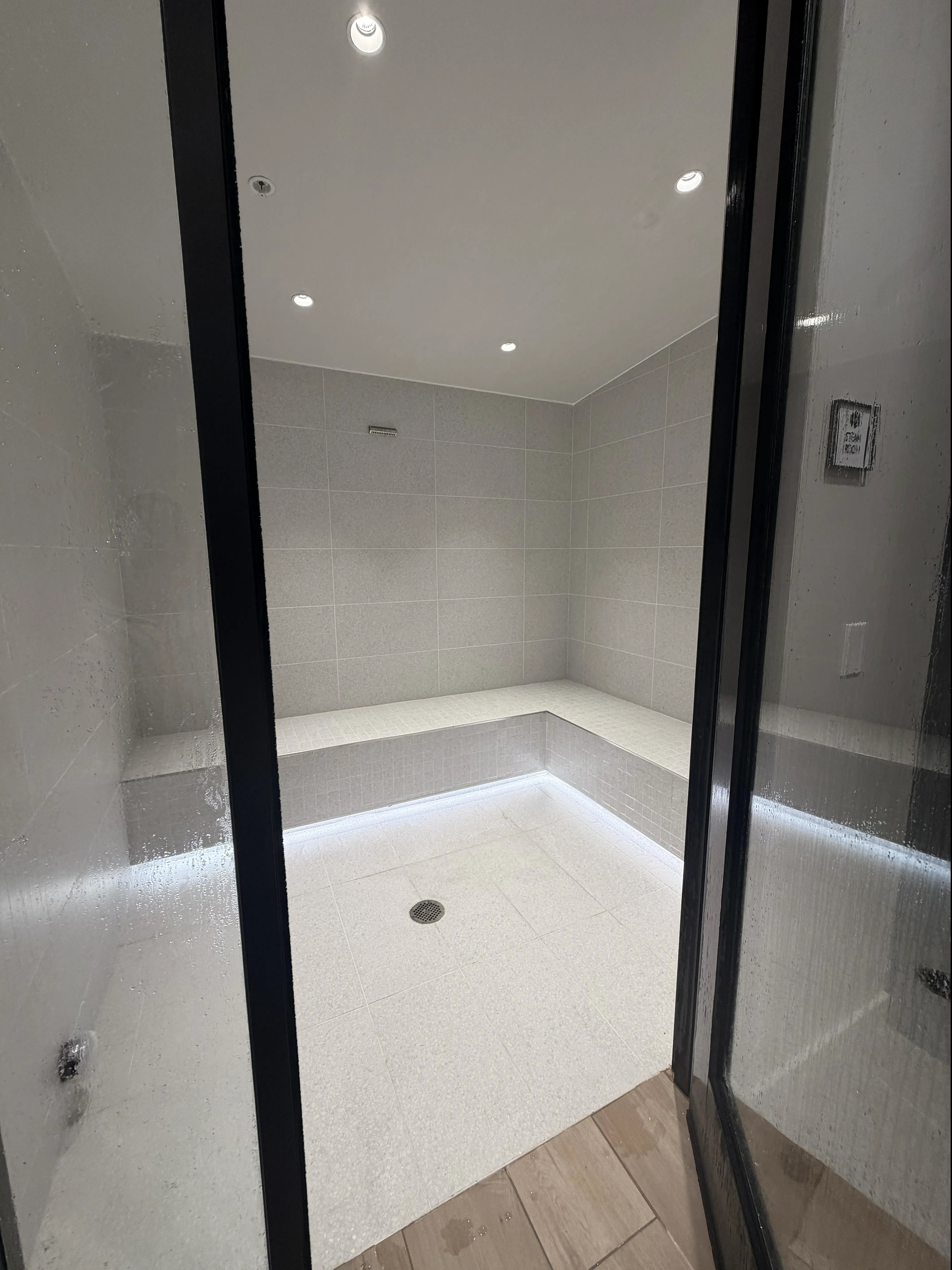 Contemporary steam room with sleek tile design and ambient lighting, offering a luxurious relaxation space.