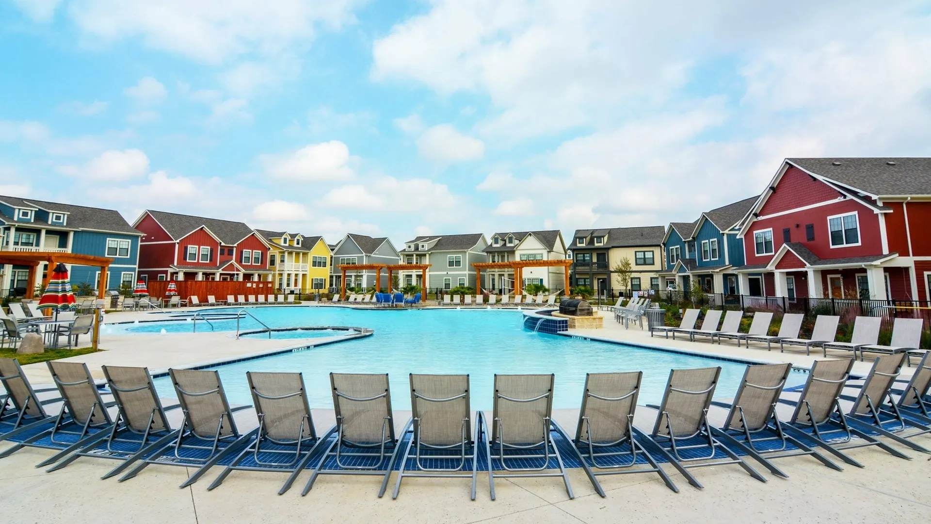 Swimming pool with lounge chairs facing building