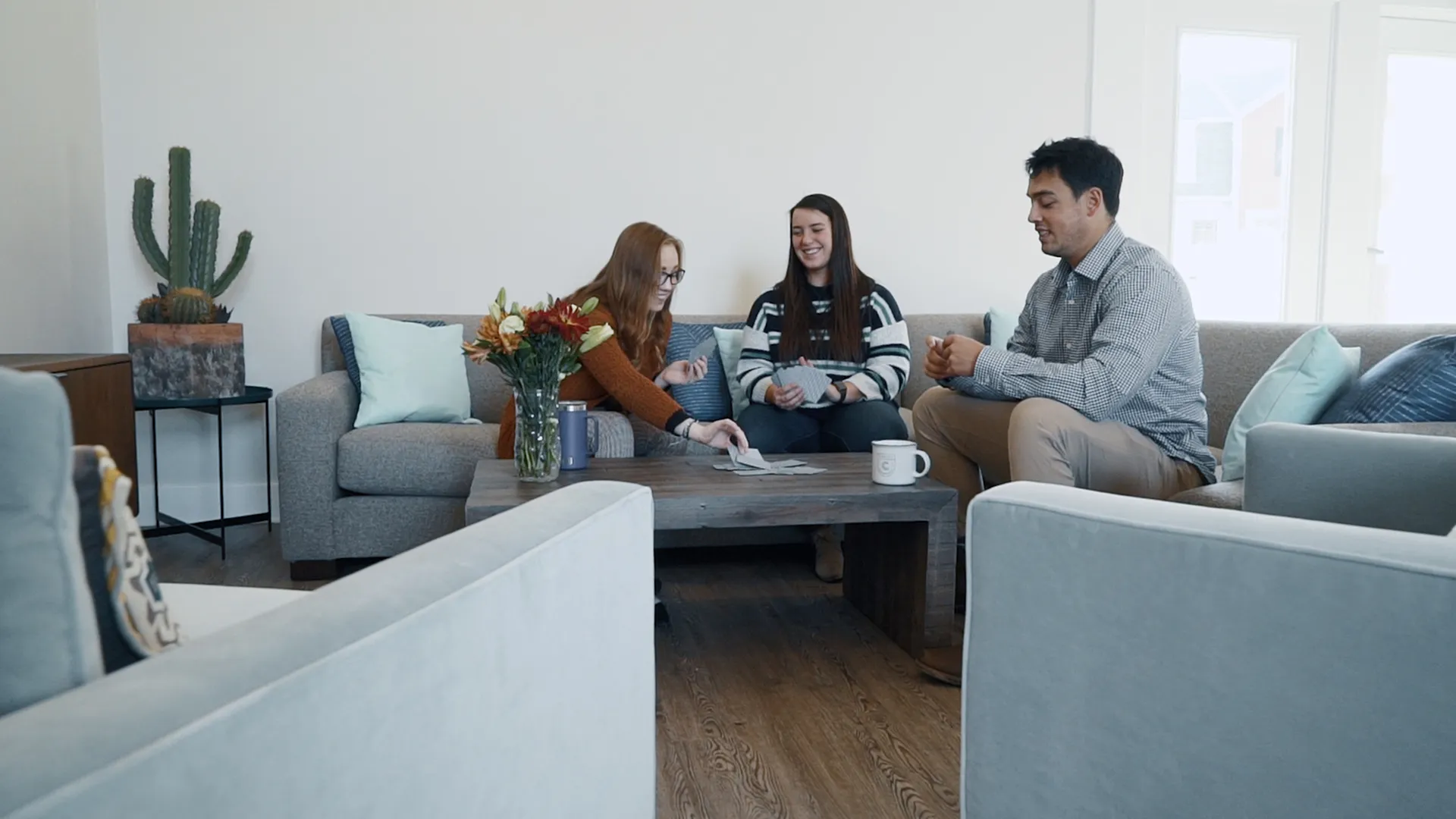 Welcoming living room with modern decor, featuring a cozy seating area and natural light providing a perfect space for gatherings.