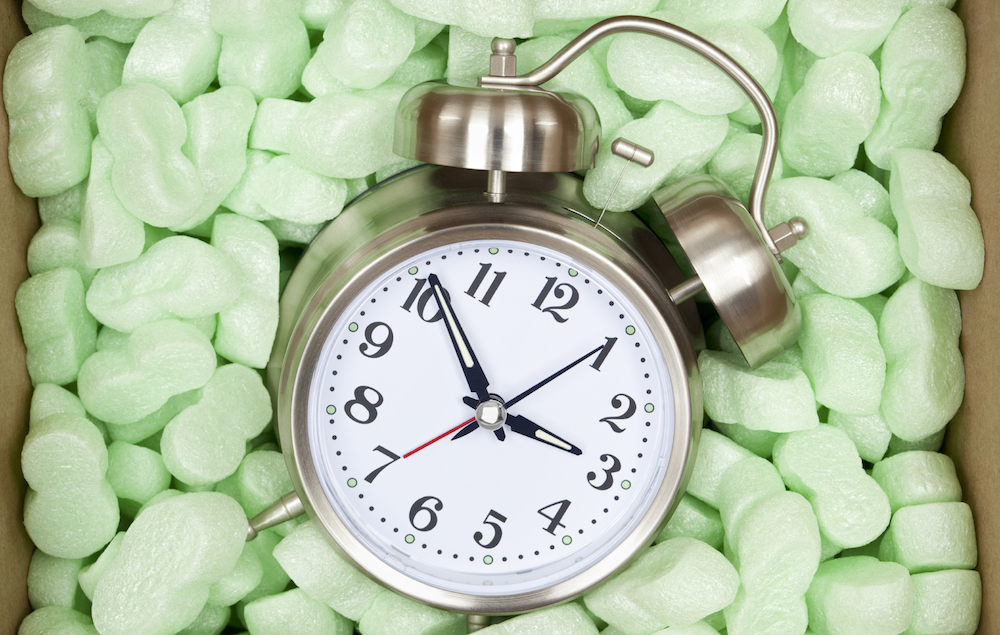 Alarm clock in a shipping box with packing peanuts. Concept for receiving more time, or how fragile our time is.