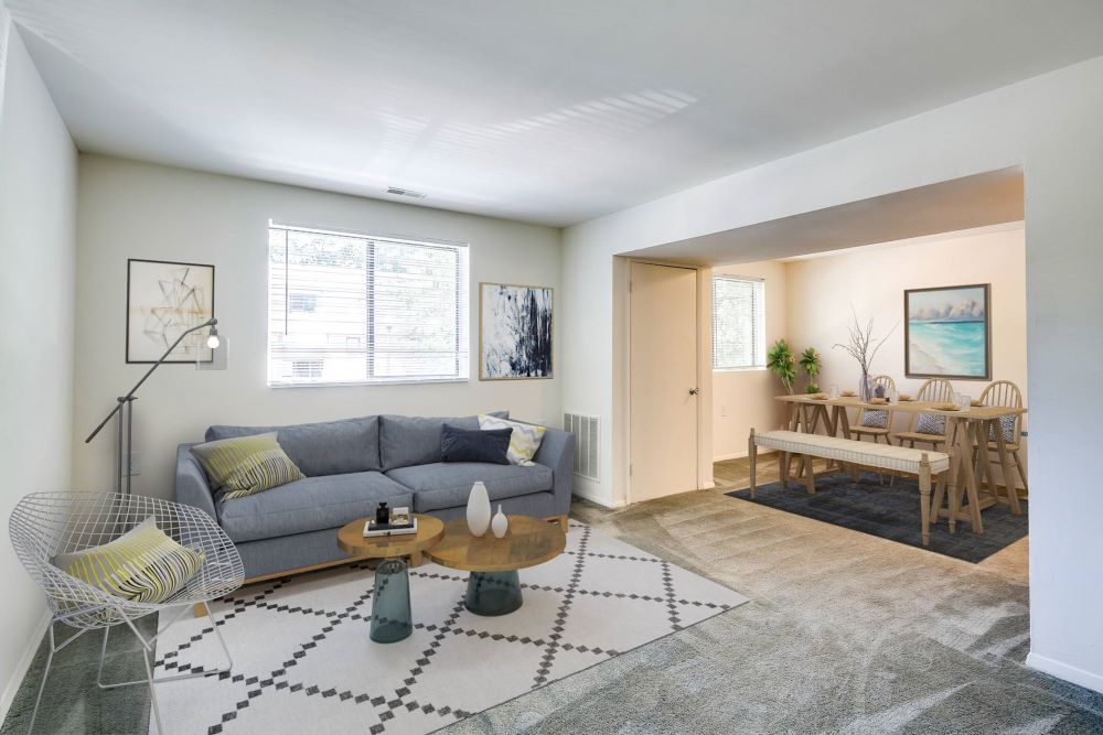Cozy living and dining area in Butler Ridge Apartments featuring a couch, dining table, and a stylish rug.
