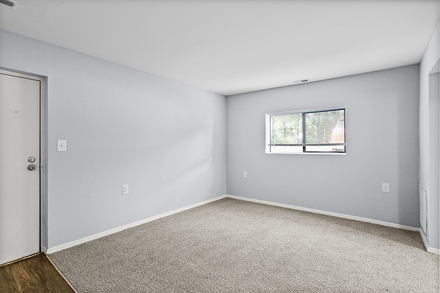 Bright and inviting room with fresh carpet and ample natural light, ideal for a cozy living space.