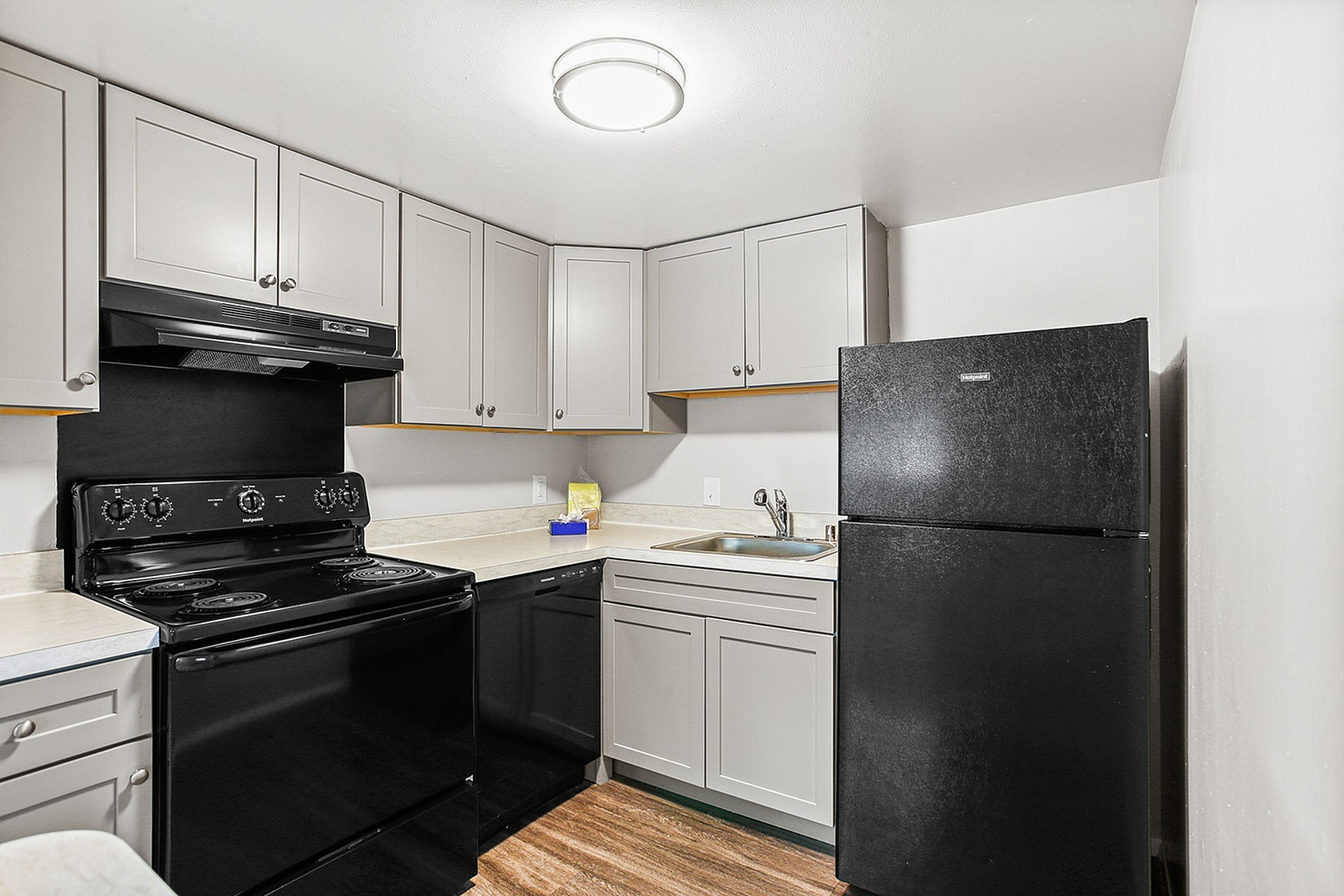 Modern kitchen with sleek black appliances, chic cabinetry, and elegant countertops, ideal for culinary creativity.
