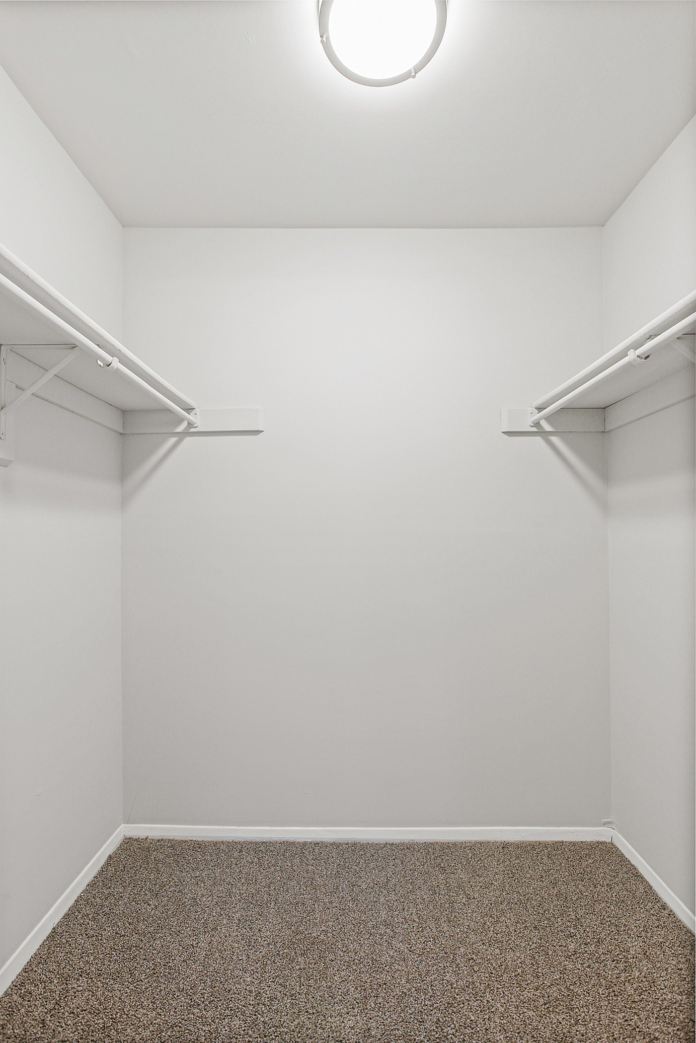 Spacious walk-in closet with ample hanging space and modern lighting.