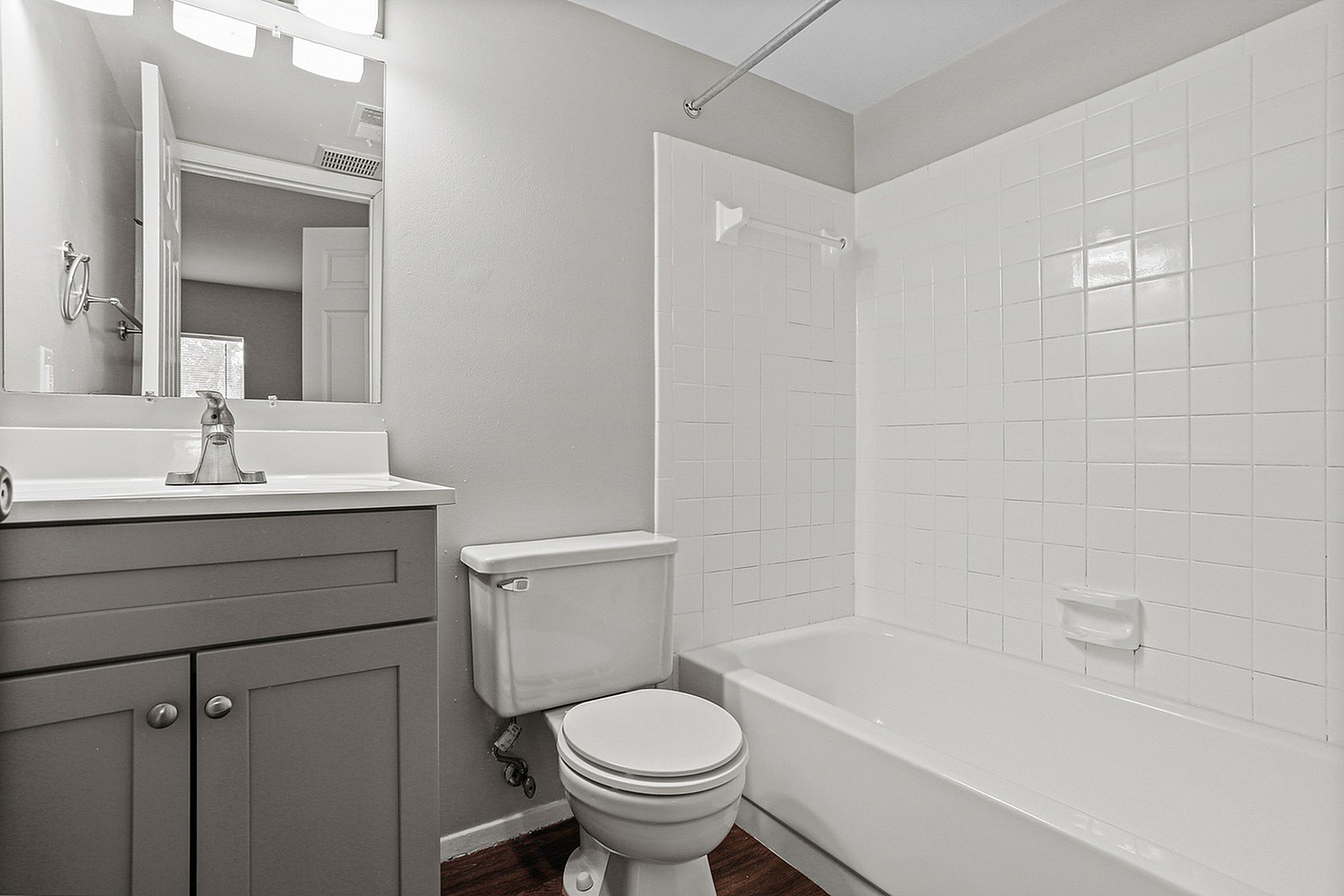 Elegant bathroom with sleek vanity, pristine white tiles, and a modern bathtub, offering a serene and stylish space.