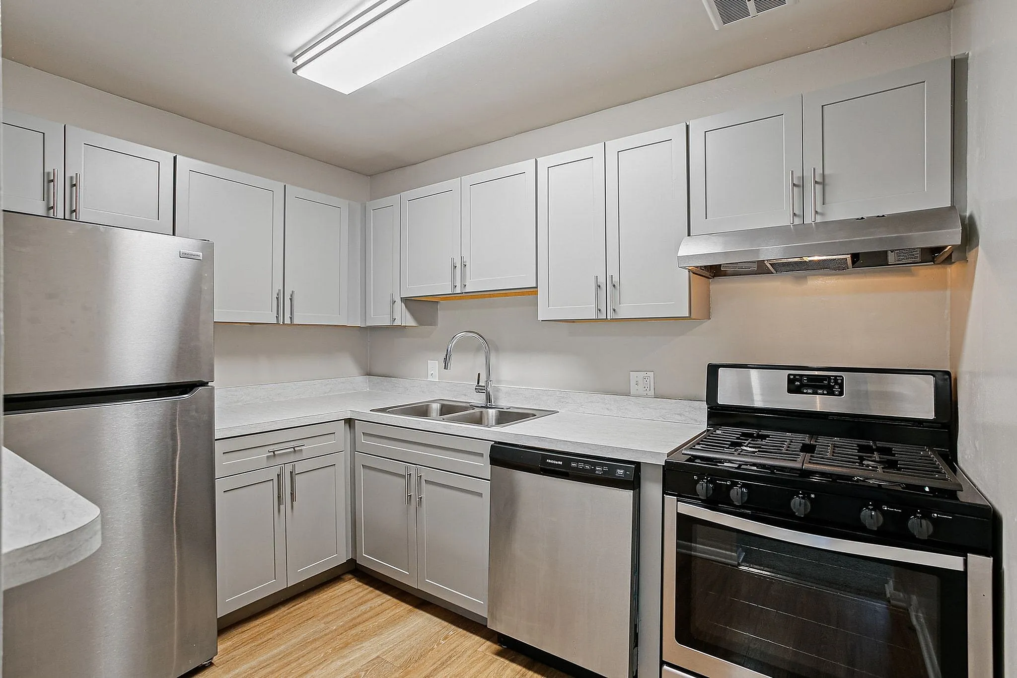 Modern kitchen with sleek stainless steel appliances, elegant white cabinetry, and stylish marble countertops.