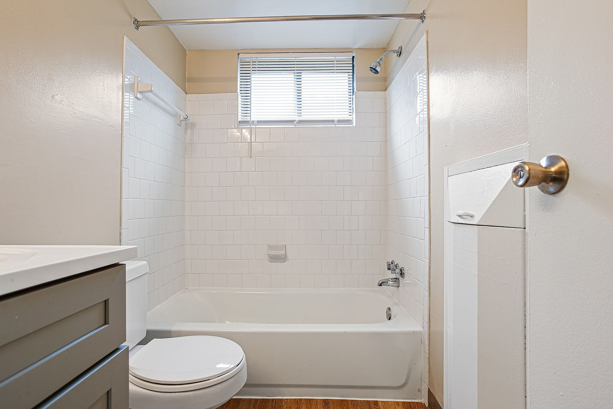 Bright and modern bathroom featuring a sleek white bathtub, stylish tile walls, and natural light from a window above.